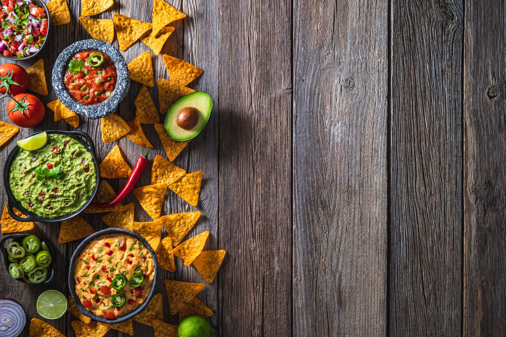 Tortilla chips with salsa and dips on a rustic table