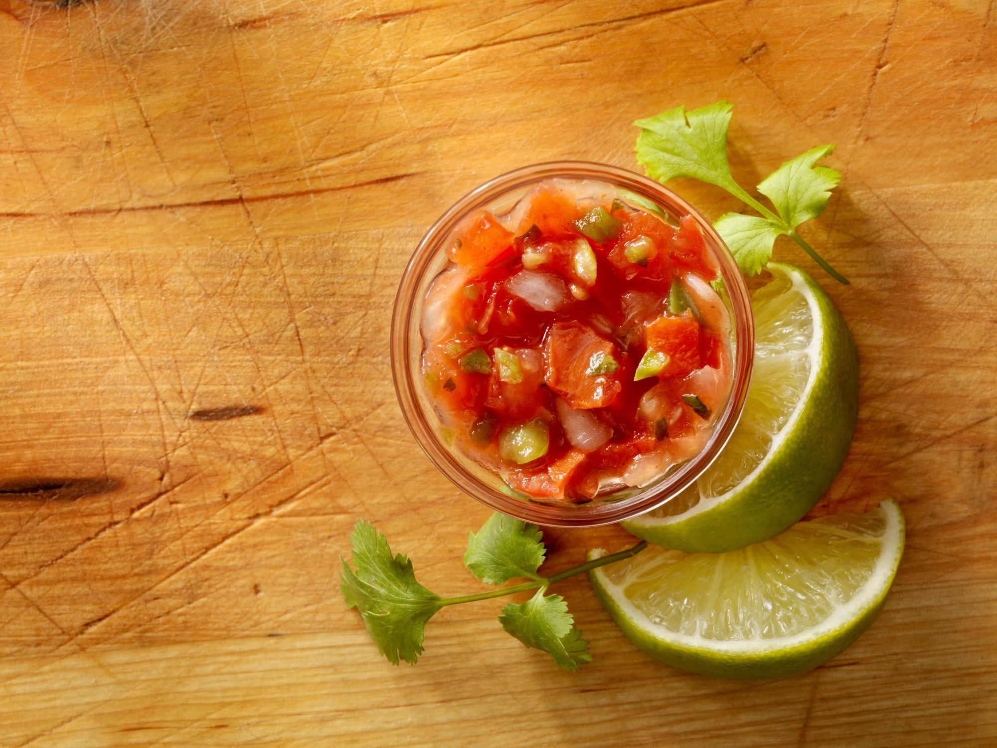 Jar of fresh salsa with lime and cilantro